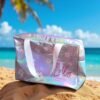 Silvery iridescent tote bag with white handles, adorned with daisies and "Lolly" in pink script, rests on sand. Palm tree and ocean in background. Serene, tropical vibe.