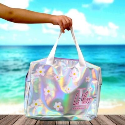 A hand holds a holographic tote bag with white daisy patterns and the word