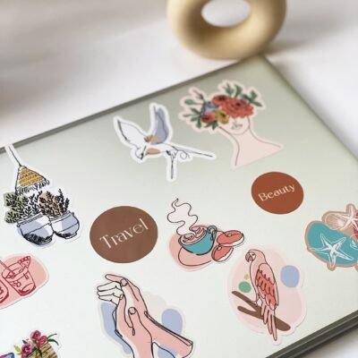 A laptop covered in colorful stickers featuring various designs and patterns.