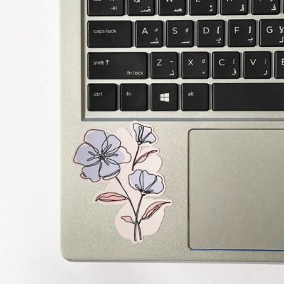 A decorative flower sticker on a laptop keyboard, showcasing a blend of technology and nature.
