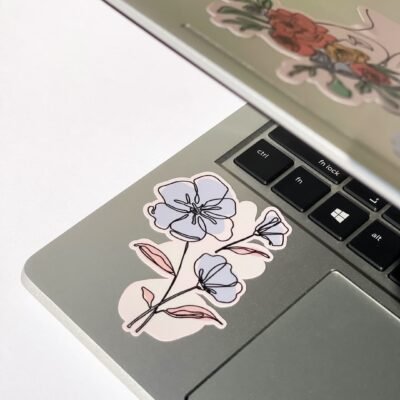 A laptop covered in various flower stickers, reflecting a cheerful and artistic aesthetic.