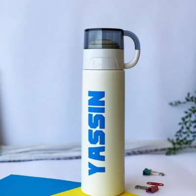 Sleek white thermos with a black lid and a handle, featuring 