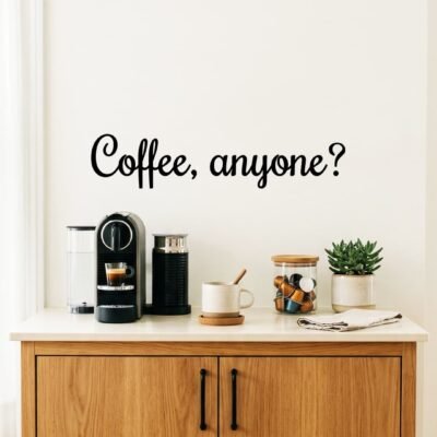 Modern kitchen counter with a coffee machine, mug, jar of coffee pods, and a potted plant. Text on the wall reads, "Coffee, anyone?"