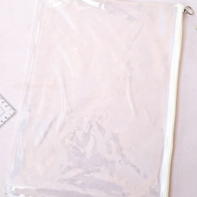 Clear plastic zippered file lying on a pale surface, with colorful stationery peeking in at the corners; simple, clean, practical tone.
